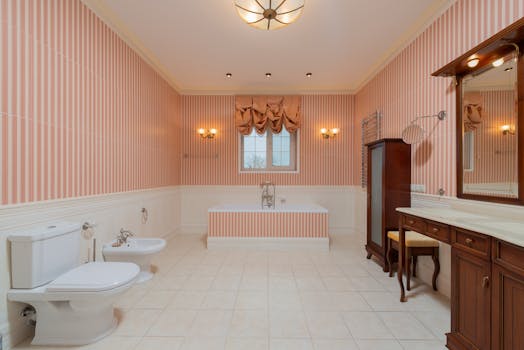 A spacious bathroom with elegant decor including a bathtub, toilet, and classic furniture.